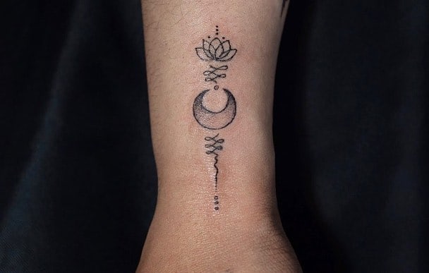 Unalome tattoo with a lotus and crescent moon on the wrist, symbolizing spiritual enlightenment, balance, and the journey toward inner peace.