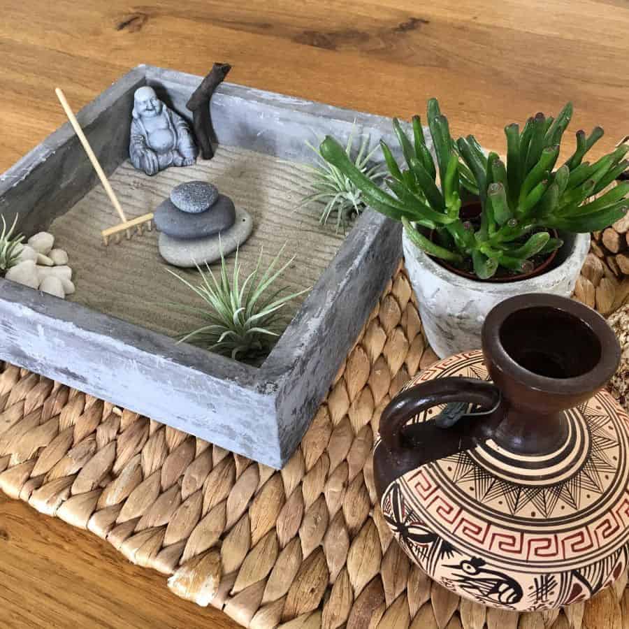 small japanese rake garden with buddha statue and succulent 