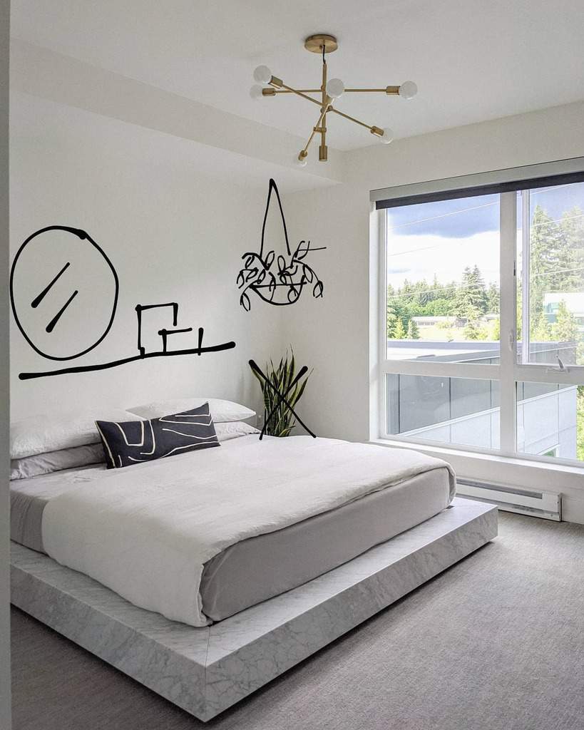 Minimalist apartment bedroom with large window, abstract wall art, and marble platform bed.