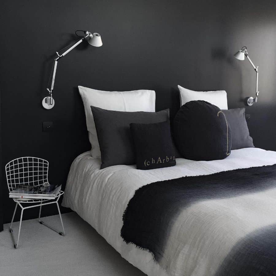 Minimalist bedroom with black walls, white bedding, and adjustable wall-mounted lamps.