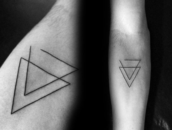 Minimalist geometric tattoo featuring overlapping thin-line triangles, creating a modern and abstract design on the forearm.