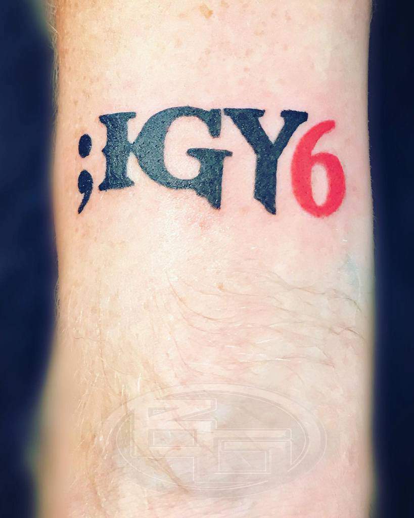 Bold 'IGY6' tattoo featuring a black semicolon and red 6, symbolizing solidarity and mental health awareness