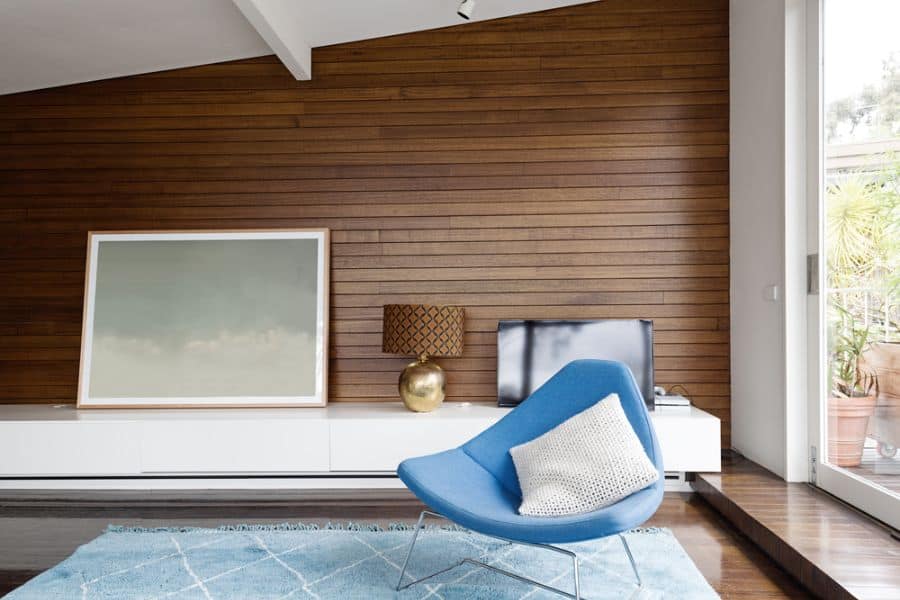 wood panel accent wall with blue chair in living space