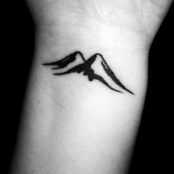 Bold minimalist mountain tattoo on the wrist, featuring thick black lines and sharp peaks for a striking and simple nature-inspired design.