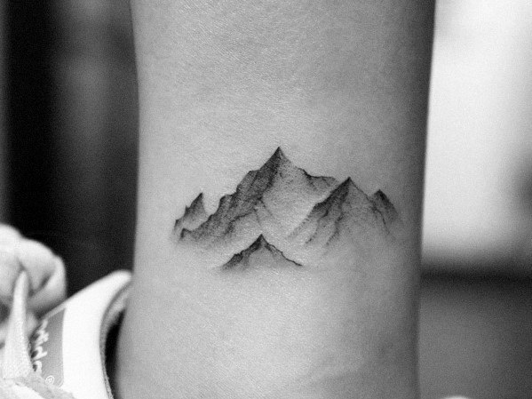 Realistic mountain tattoo on the wrist, featuring soft shading and fine details for a subtle yet detailed nature-inspired design.