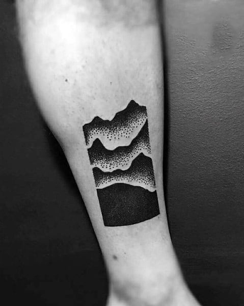 Bold geometric mountain tattoo on the leg, featuring layered peaks with dot shading and a solid black background for a modern and artistic design.