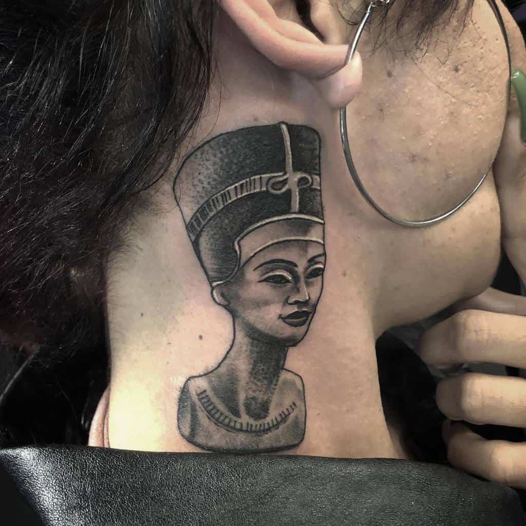 Tattoo of Nefertiti on a neck, showcasing an ancient Egyptian queen with a large hoop earring visible