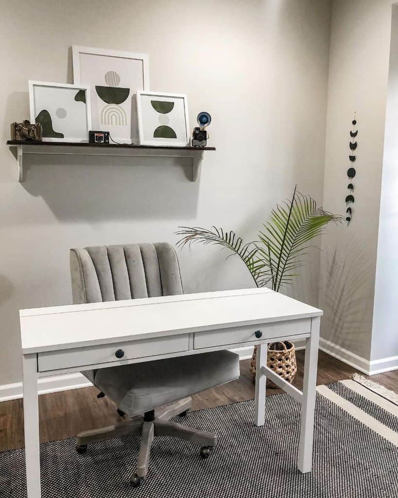 minimalist home office wood desk with drawers wall shelf with framed art gray office chair wicker basket
