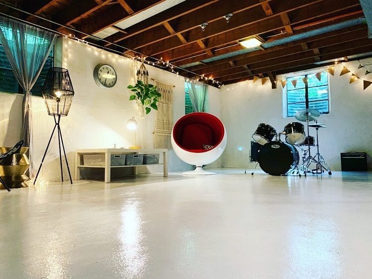 large basement space white concrete floors egg chair drum kit 