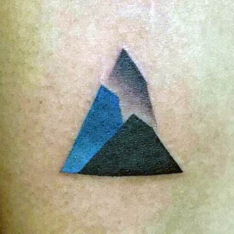 Geometric mountain tattoo with black, gray, and blue shades
