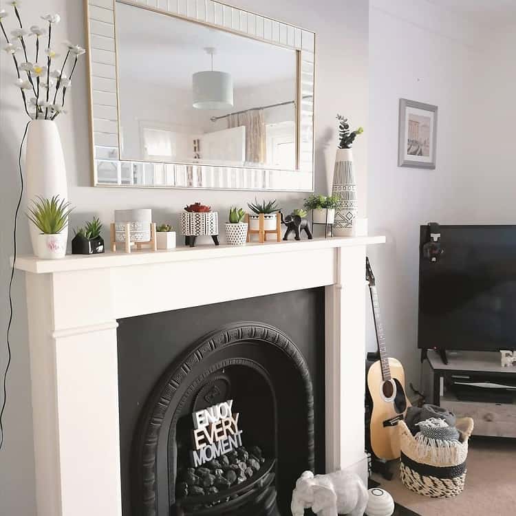 fireplace with white mantle and wall mirror