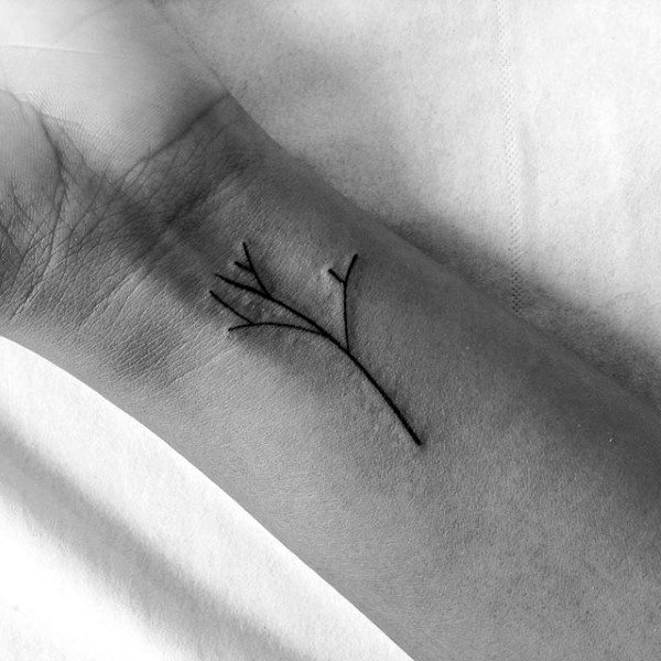 Minimalist tree tattoo on the wrist in black ink