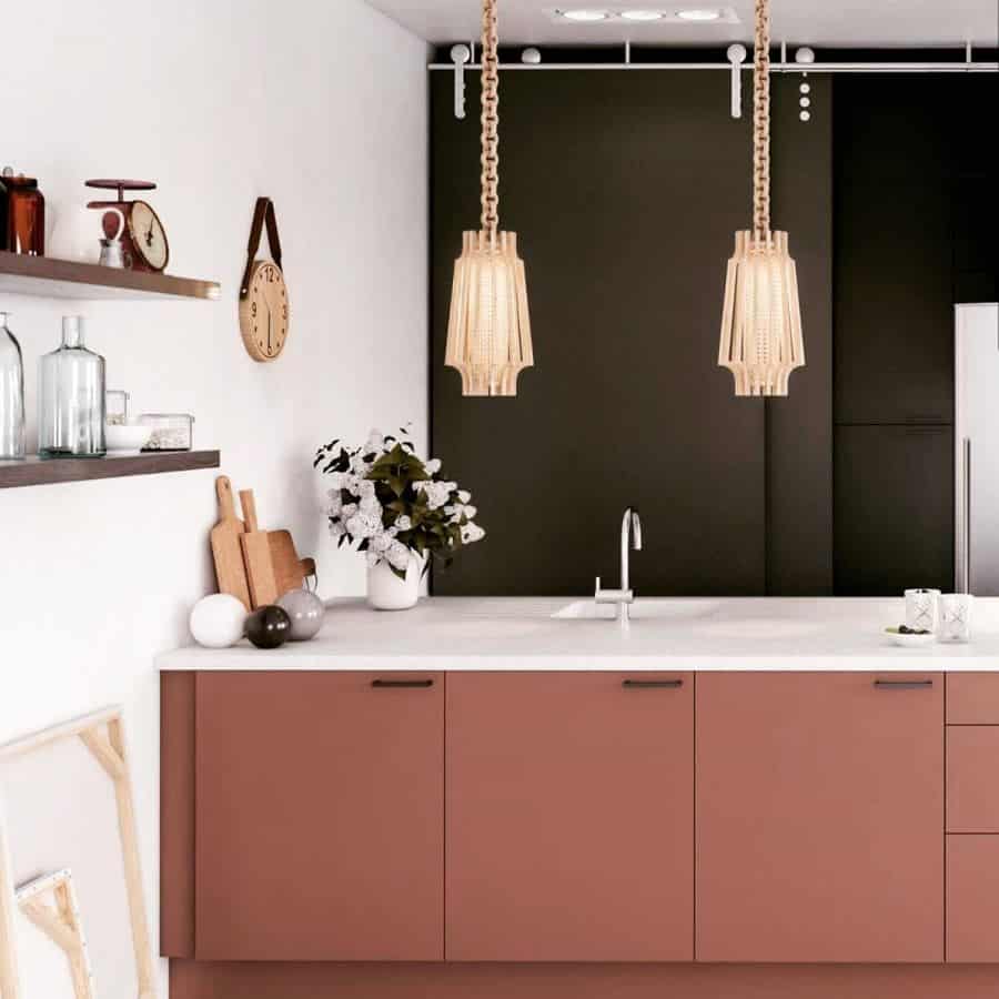 A sleek kitchen with terracotta cabinets, white countertops, warm wooden pendant lights, and minimalist decor elements.