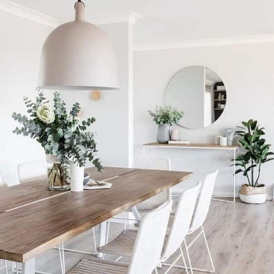 dining room wood table white chairs wall mirror flowers