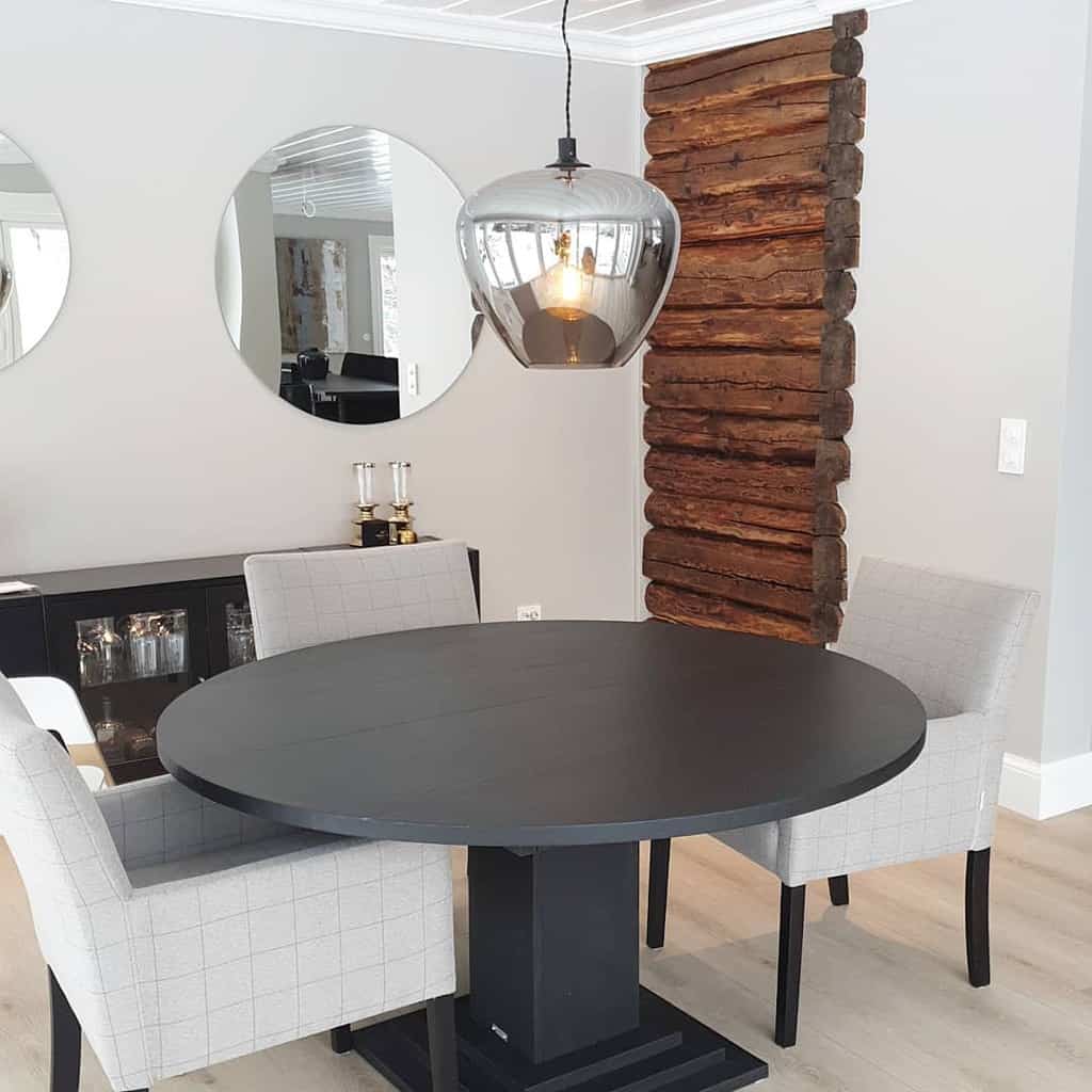 modern dining room black circular table and gray chairs wall mirrors wood log wall feature 