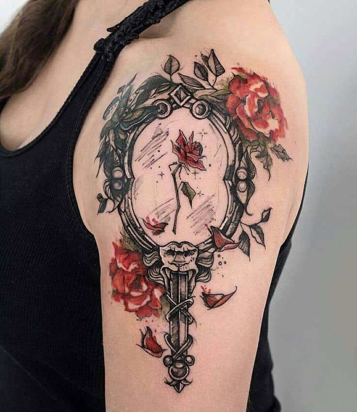 Ornate mirror tattoo featuring the enchanted rose with a cracked glass effect, surrounded by red roses and delicate falling petals.