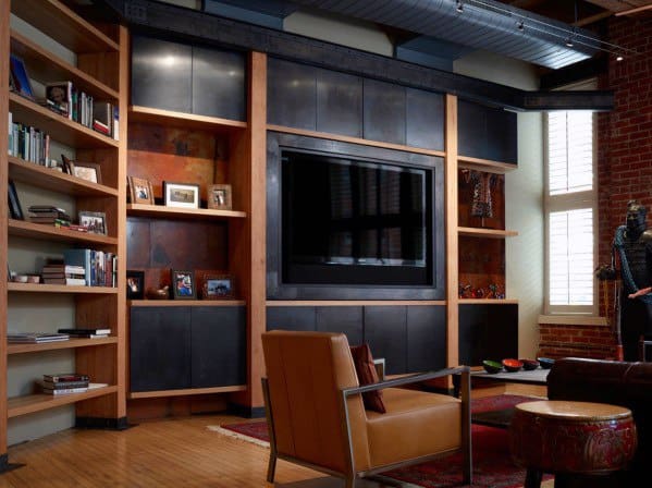 Cozy living room with leather chairs, a large TV, bookshelves, and natural light from tall windows