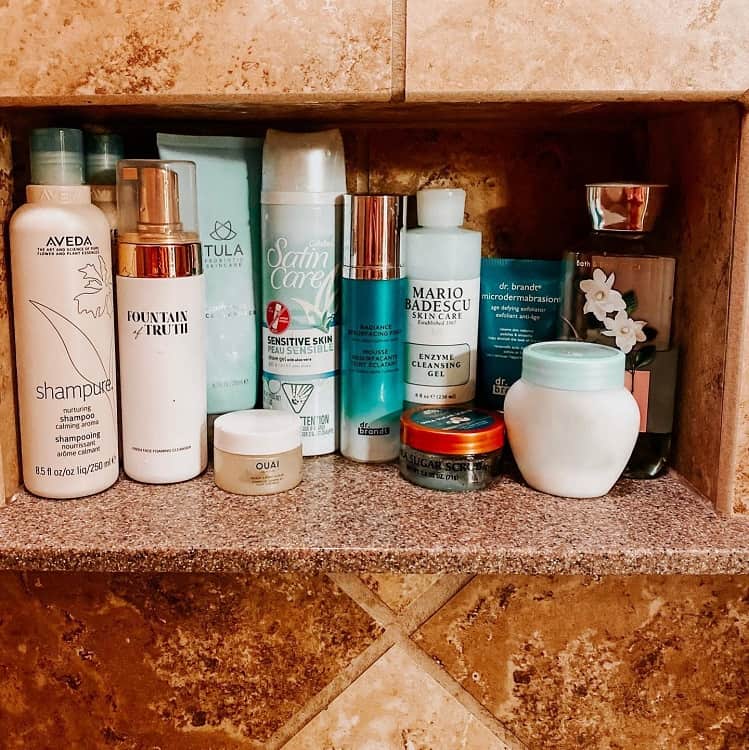 Modern bathroom recessed shelf with skincare and bath products.