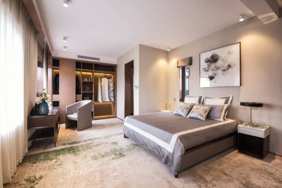 Spacious modern bedroom with open closet, soft lighting, and elegant decor.