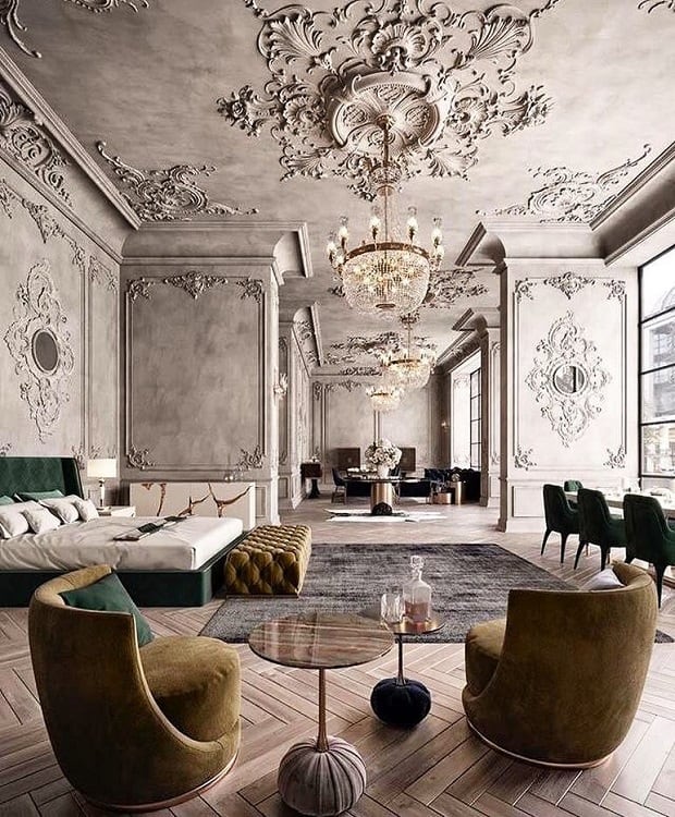 Luxurious room with ornate ceiling, chandeliers, a bed, green chairs, and large windows
