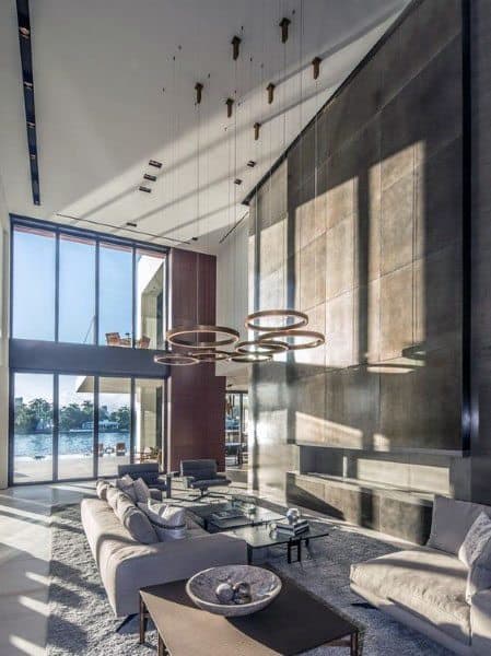 Spacious, sleek living room with tall windows and circular chandeliers