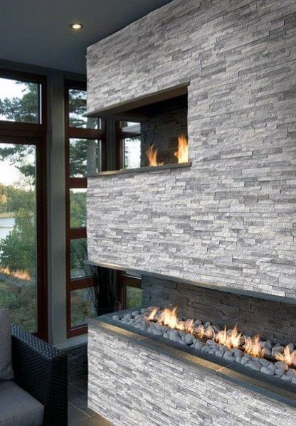 Modern stacked stone fireplace with dual fire features, creating a warm and stylish corner ambiance