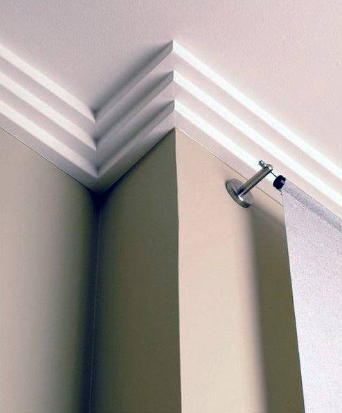 Modern corner crown molding with sharp, geometric angles and a minimalistic design, complementing the sleek curtain setup