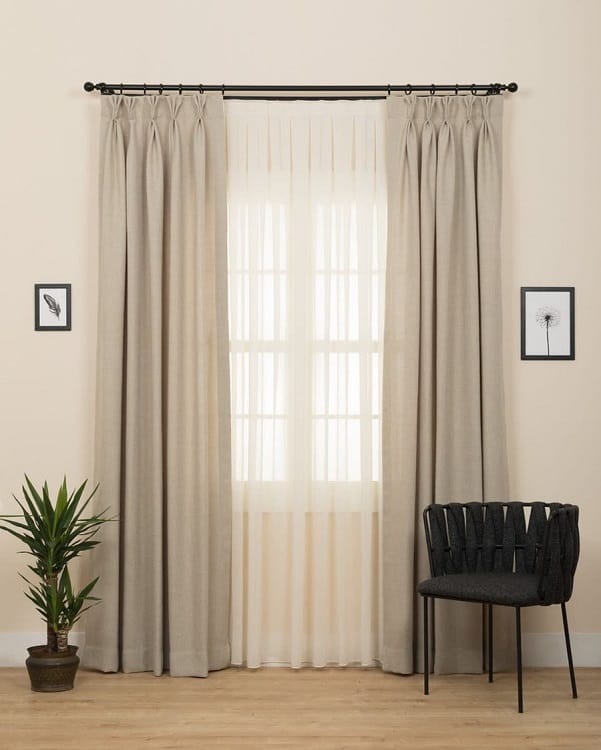 simple living space black chair beige curtains plant