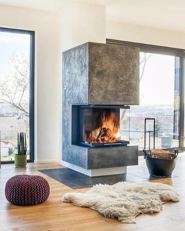 Corner fireplace with concrete finish, glass panels, and cozy modern living room decor.