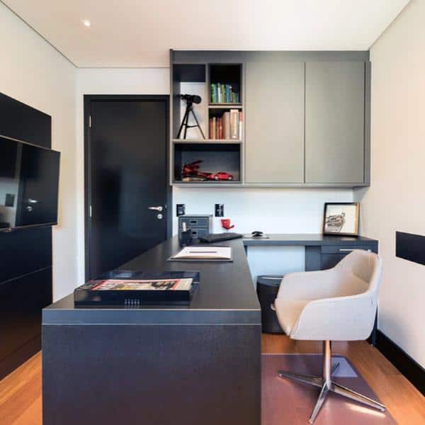 Compact home office with sleek black desk, grey cabinets, and a modern swivel chair.