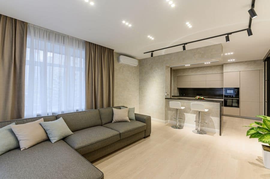modern open plan living room kitchen gray sofa track lighting 