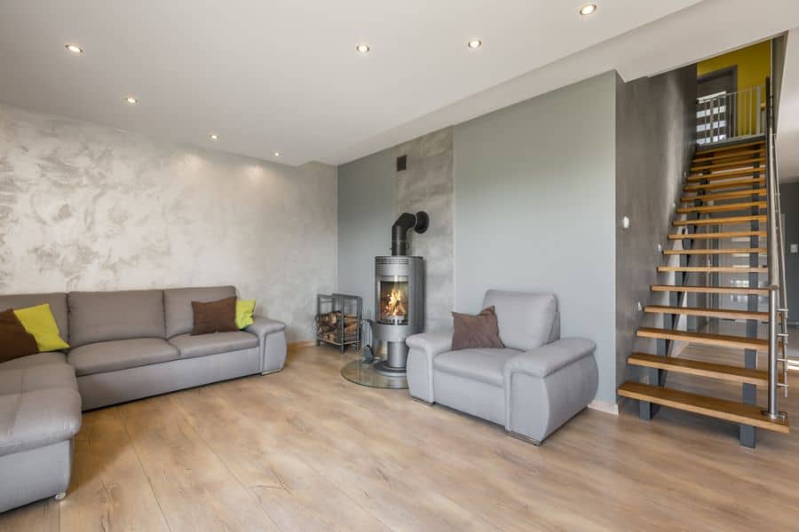 downstairs living room modern fireplace gray couch pattern feature wall