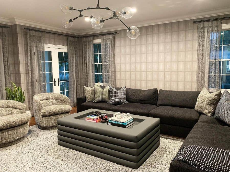 modern family room pattern wallpaper large black couch sputnik chandelier