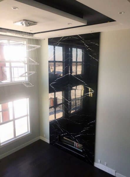Black marble fireplace with sleek, floor-to-ceiling elegance, creating a bold and luxurious focal point.