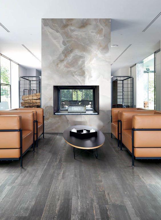 A double-sided fireplace with a marble finish seamlessly divides spaces while offering warmth and luxury to both areas.