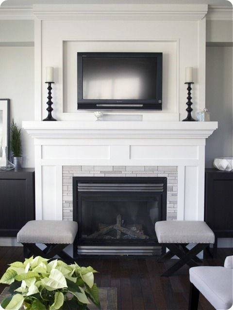 This fireplace features a classic white mantel with clean lines, a tiled surround, and a black framed gas insert.