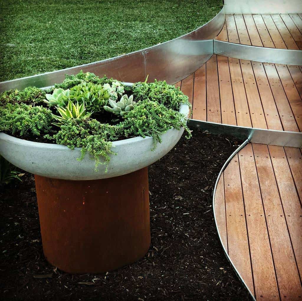curved metal edging wood deck succulents