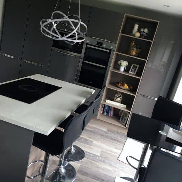 Glossy grey kitchen cabinets with white countertops, open shelving, and modern pendant light.