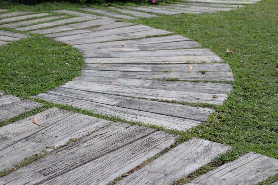 Curved wooden walkway on green grass