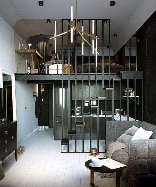 Modern studio with loft bed, black metal partitions, sleek kitchen, and cozy seating area.