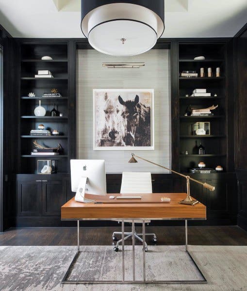 Modern home office with wood desk, black built-in shelves, and horse artwork centerpiece.