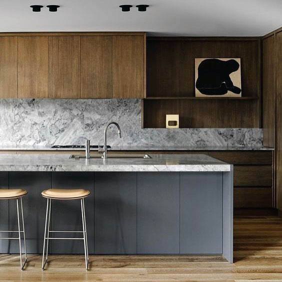 Modern kitchen with a sleek blend of natural wood cabinetry, gray island, and marble backsplash for a contemporary aesthetic.