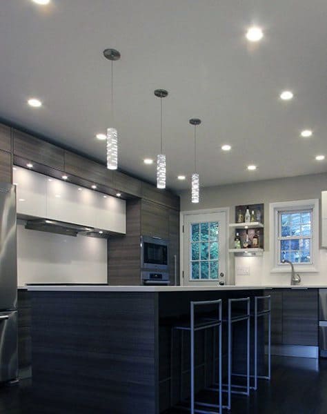 Contemporary kitchen with dark cabinetry, modern pendant lighting, and minimalist island seating.