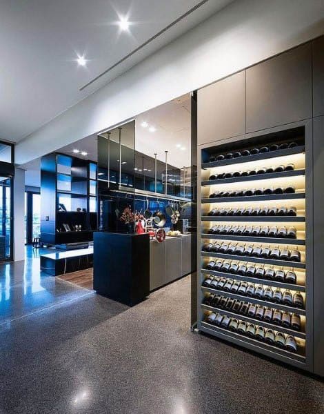 Sophisticated modern kitchen featuring a built-in illuminated wine storage wall and polished finishes.