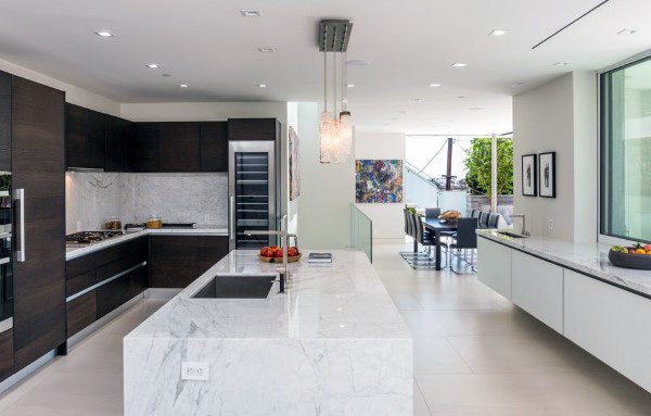 Contemporary kitchen with marble island, dark wood cabinets, and open dining area.