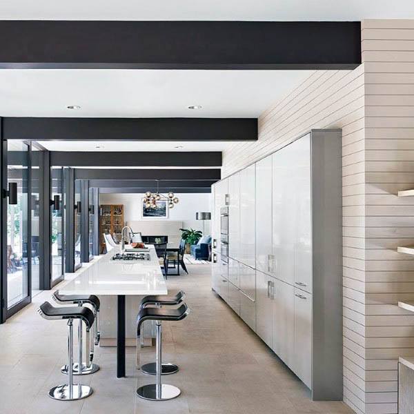Sleek modern kitchen with high-gloss cabinetry, a minimalist white island, and chic bar stools.