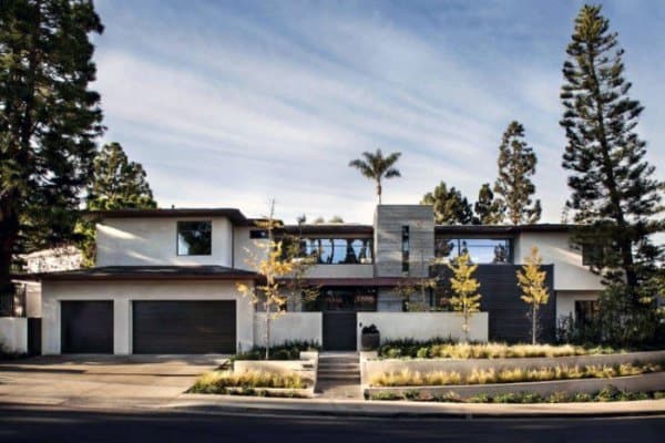 Modern home with clean landscaping, symmetrical pathways, and sleek trees for curb appeal.