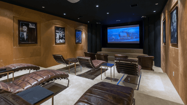 Home theater with leather recliners, artwork on walls, and a large screen creating the perfect ambiance