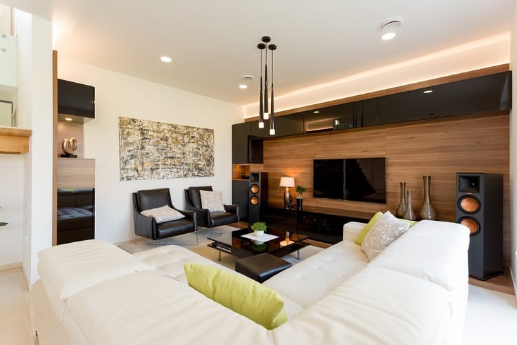 modern living room large stereo speakers wall mounted tv black accent chairs white l-shape sofa 