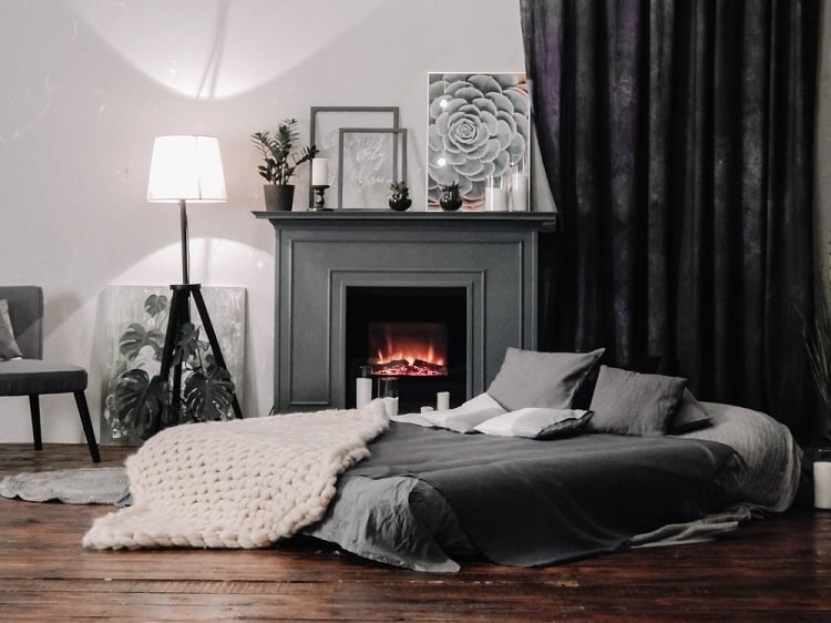 monochrome living room with gray fireplace and bed